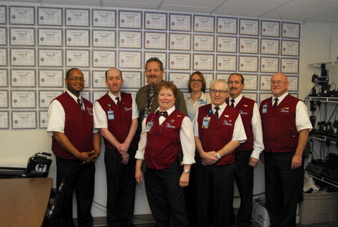 Employees at IND standing in front of their "Super Service" Certificates